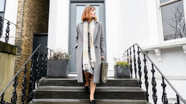 Article thumbnail: Businesswoman in her 30s leaving home in the morning, looking sideways and carrying briefcase, she is descending steps outside front door and setting off on her morning commute